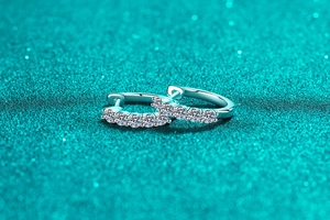 Nahaufnahme von S925 Sterling Silber Creolen mit Pavé-Moissanit auf blauem Hintergrund