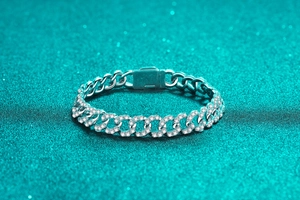Macro shot of Cuban link bracelet featuring micro-pave stones and polished silver finish