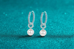 Detailed macro view of S925 silver earrings with pavé moissanite and round freshwater pearls