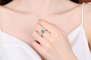 Close-up of S925 silver ring with blue moissanite sunflower halo on finger