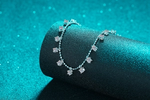 Macro shot of S925 sterling silver moissanite necklace on a textured grey display stand