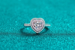 Makroaufnahme eines Herz-Moissanit-Rings mit rosa und weißem Pave-Halo-Besatz