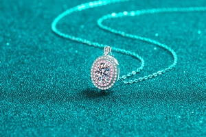 Macro shot of oval halo pendant with central white stone and pink gem border
