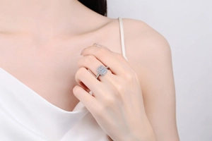 Close-up of radiant cut moissanite ring with double halo setting on a model finger