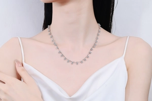 Close-up of S925 sterling silver necklace with light blue moissanite charms on model