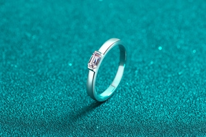 Macro shot of an emerald cut moissanite set on a polished S925 silver ring band