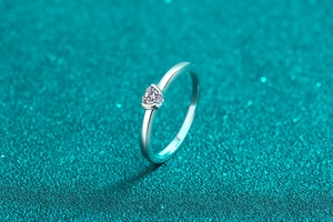 Detailansicht eines Herz-Moissanit-Rings aus 925er Silber auf glitzerndem Hintergrund