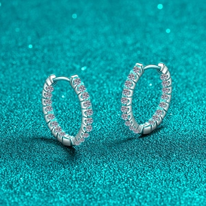 Exquisite S925 Sterling Silber Creolen mit Moissanit-Besatz auf blauem Glitzerhintergrund
