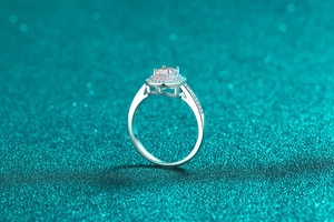 Macro view of a round moissanite ring with pink and white halo and micro-pave band
