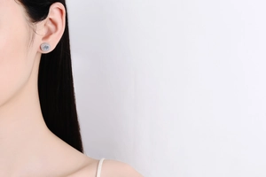 Close-up of 925 sterling silver egg-shaped moissanite stud earring on a model