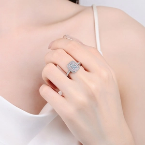 Radiant emerald cut moissanite ring in 925 silver with pink halo on a model's finger