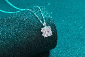 Gros plan sur un pendentif carré en moissanite avec pierres roses sur chaîne en argent