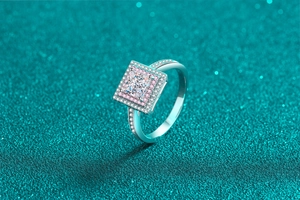 Macro view of square cut diamond ring with pink pave stones on silver band