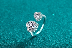 Macro detail of twin heart-shaped Moissanite stones with halo setting on a silver ring