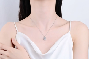 Detail of S925 sterling silver necklace featuring emerald cut light blue gemstone pendant