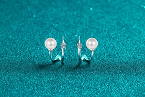 Detail of wavy S925 silver earrings with round freshwater pearl and moissanite stone