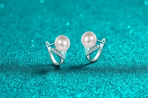 Macro view of S925 silver V-shaped earrings with freshwater pearls and pavé moissanite