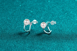 Macro shot of S925 sterling silver U-shaped earrings with pearls and moissanite stones