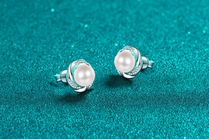Gros plan sur les boucles d'oreilles vagues en argent avec perles d'eau douce