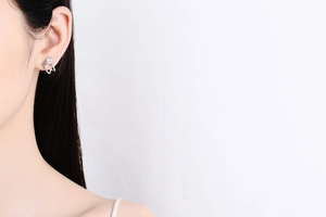 Close-up of S925 sterling silver U-shaped earring with white pearl and blue accent