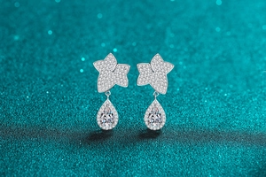 Macro shot of maple leaf silver earrings with sparkling pear-shaped moissanite drops