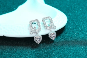 Macro shot of S925 sterling silver Q-letter earrings with heart-cut moissanite stone