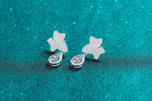 Macro view of S925 sterling silver maple leaf earrings with pear-cut moissanite stones