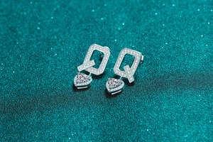 Macro shot of S925 sterling silver Q-shaped earrings with heart-cut moissanite stones
