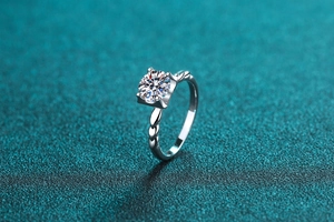 Macro detail of S925 silver ring featuring a round moissanite with twisted petal setting