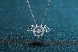 Macro shot of 925 silver devil pendant with shimmering dancing moissanite on blue background