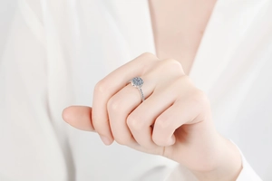 Gros plan sur bague en argent S925 avec grappe de moissanite bleue et diamants au doigt