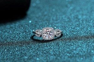 Macro view of S925 sterling silver moissanite halo ring with pear-shaped side accents