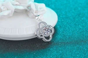 Detailed shot of silver four-leaf clover necklace with round 1-carat moissanite stone