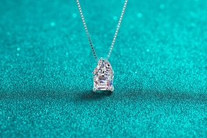 Detail of silver box chain necklace with heart and emerald cut moissanite pendant