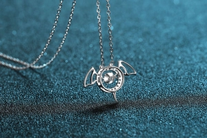 Macro view of S925 sterling silver devil wing pendant with dancing moissanite stone