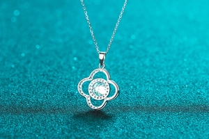 Macro shot of silver four-leaf clover pendant with 1-carat moissanite on cross chain