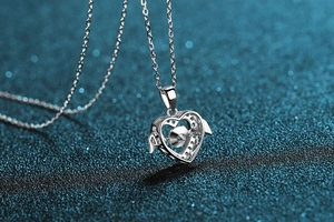 Vue macro du collier cœur avec ailes en argent S925 et pierre de moissanite scintillante