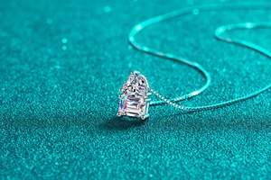 Macro detail of S925 sterling silver necklace with heart and emerald cut moissanite stones