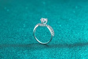 Close-up of a heart-shaped moissanite ring with small side diamonds on 925 silver