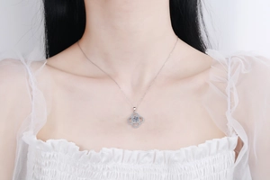 Close-up of S925 sterling silver four-leaf clover necklace with 1ct moissanite on model