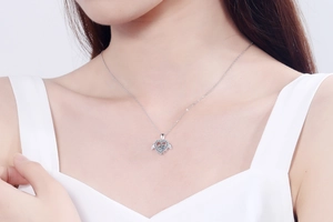 Gros plan d'un collier cœur en argent S925 avec ailes d'ange sur cou de femme