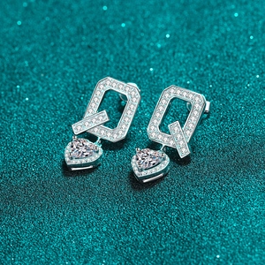 Sparkling S925 sterling silver heart earrings with Moissanite stones on glitter background