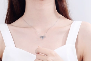 Detail of S925 silver devil horn necklace with a sparkling round moving moissanite on neck
