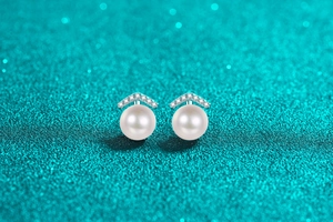 Macro shot of S925 silver stud earring with white freshwater pearl and V-shaped accents