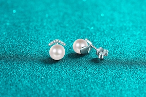 Macro shot of S925 sterling silver pearl earrings with v-shaped moissanite accents