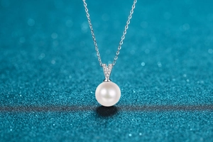 Close-up of 10mm white freshwater pearl pendant with V-shaped silver moissanite bail