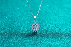 Détail du pendentif avec moissanite ovale bleu roi et sertissage halo scintillant