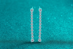 Detailed view of long linear S925 silver earrings with ten sparkling moissanite stones