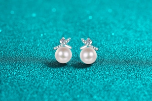 Detail shot of cross-shaped S925 silver stud earrings with 8mm pearls and micro zircons
