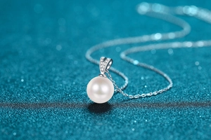 Macro shot of 10mm round freshwater pearl pendant with sparkling moissanite accents